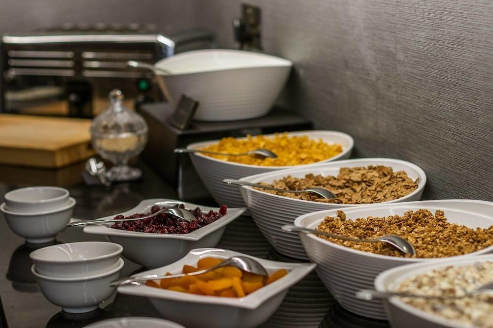 מלון לונדון Montcalm Brewery Townhouse מראה חיצוני תמונה The photo shows a variety of food items arranged on a countertop. There are several bowls containing different types of cereals and toppings. 

- One bowl features a light-colored granola.
- Another bowl holds what looks like corn flakes or a similar