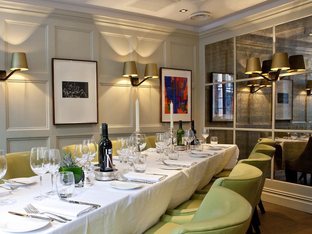 מלון לונדון Montcalm Brewery Townhouse מראה חיצוני תמונה The photo shows an elegant restaurant setting with a long dining table that is neatly set for a meal. The table is adorned with a white tablecloth, glassware, and silverware, indicating that it is prepared for a special gathering or event. 

Behind t
