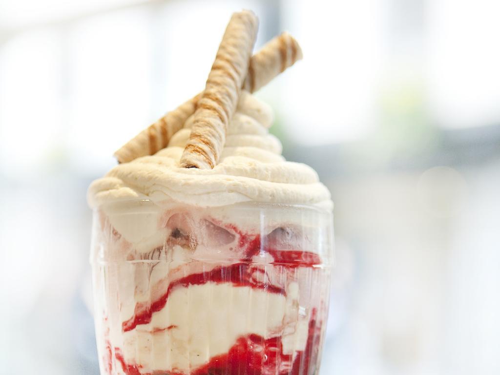 מלון לונדון Montcalm Brewery Townhouse מראה חיצוני תמונה The photo shows a delicious dessert in a clear glass dish. It features layers of creamy ice cream or whipped cream, swirled with a vibrant red fruit sauce. Topping the dessert are two rolled wafer sticks, adding a decorative touch. The overall presen