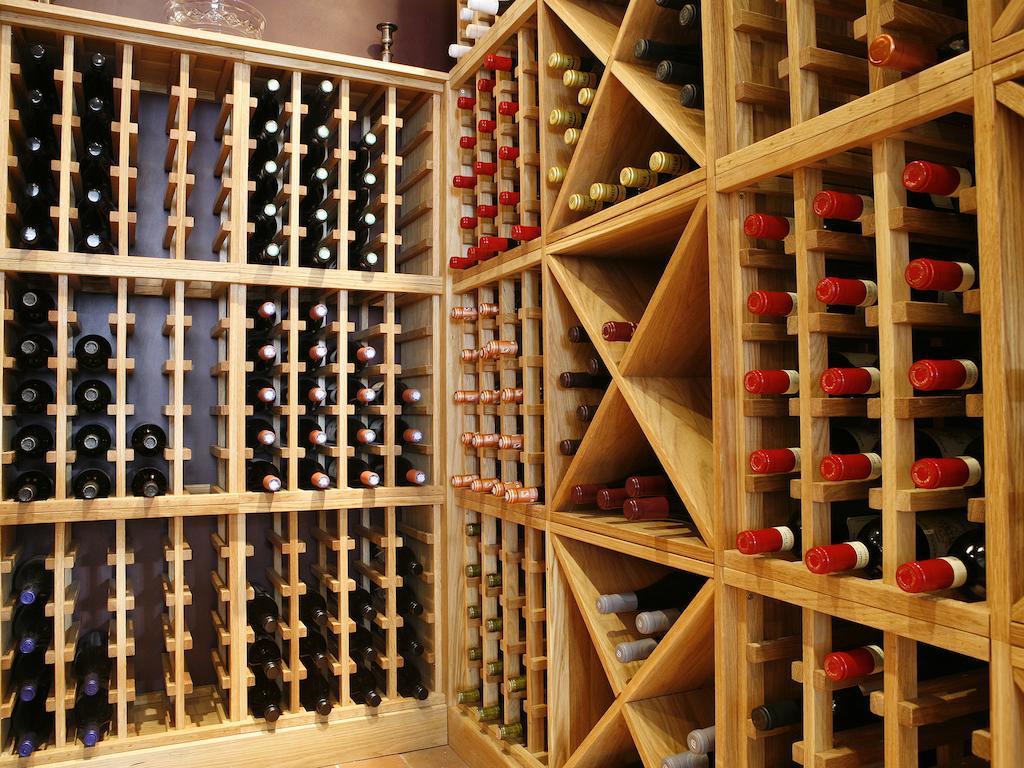 מלון לונדון Montcalm Brewery Townhouse מראה חיצוני תמונה The photo shows a wine cellar with wooden racks designed for storing wine bottles. The structure is divided into sections, featuring various compartments that hold the bottles in an organized manner. The bottles have different colors, with many red a